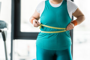 Overweight woman with measuring tape